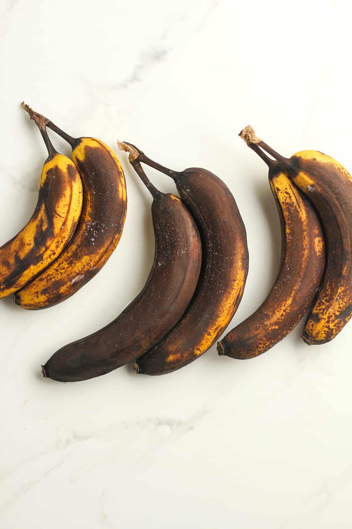 Six over-ripe bananas on a white background.