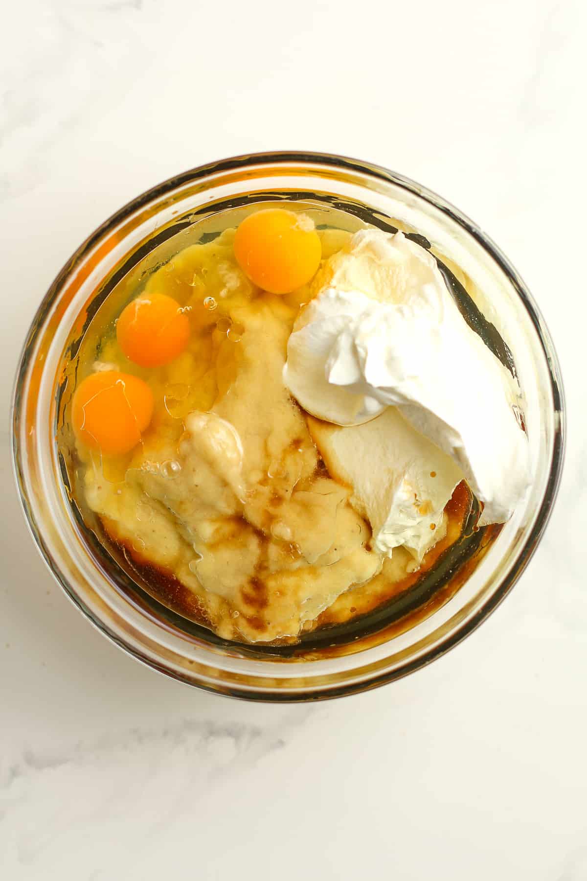 A bowl of the wet ingredients - oil, eggs, sour cream, vanilla, etc.