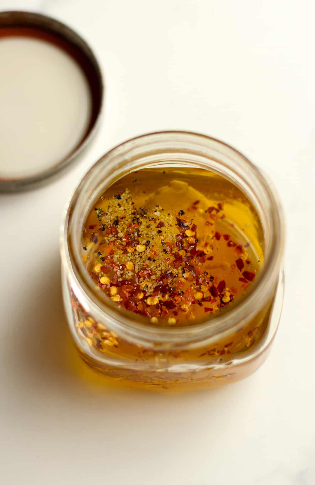 A jar of honey dijon dressing, before shaking.