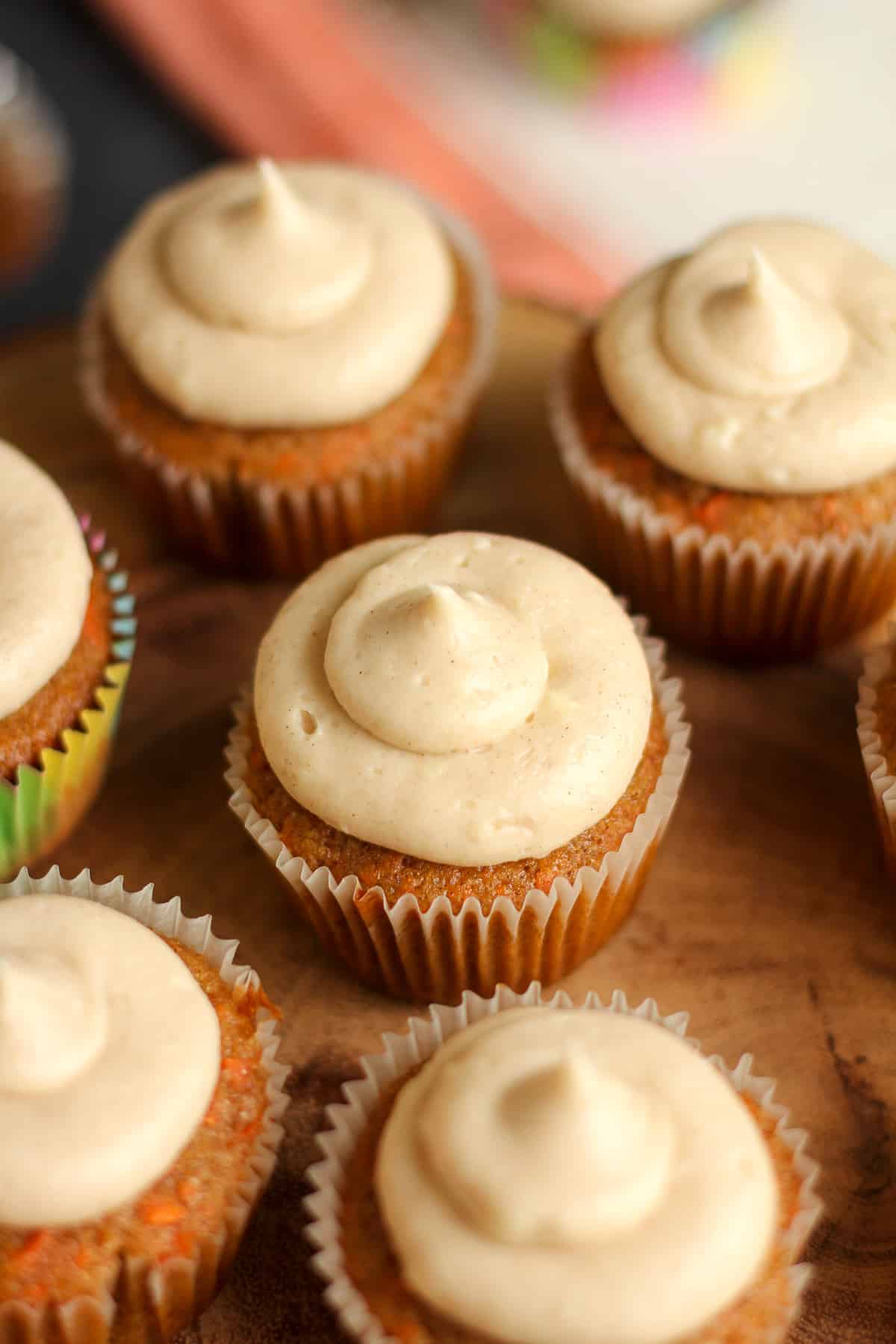 Overhead view of several carrot cake cupcakes with cream cheese frosting.