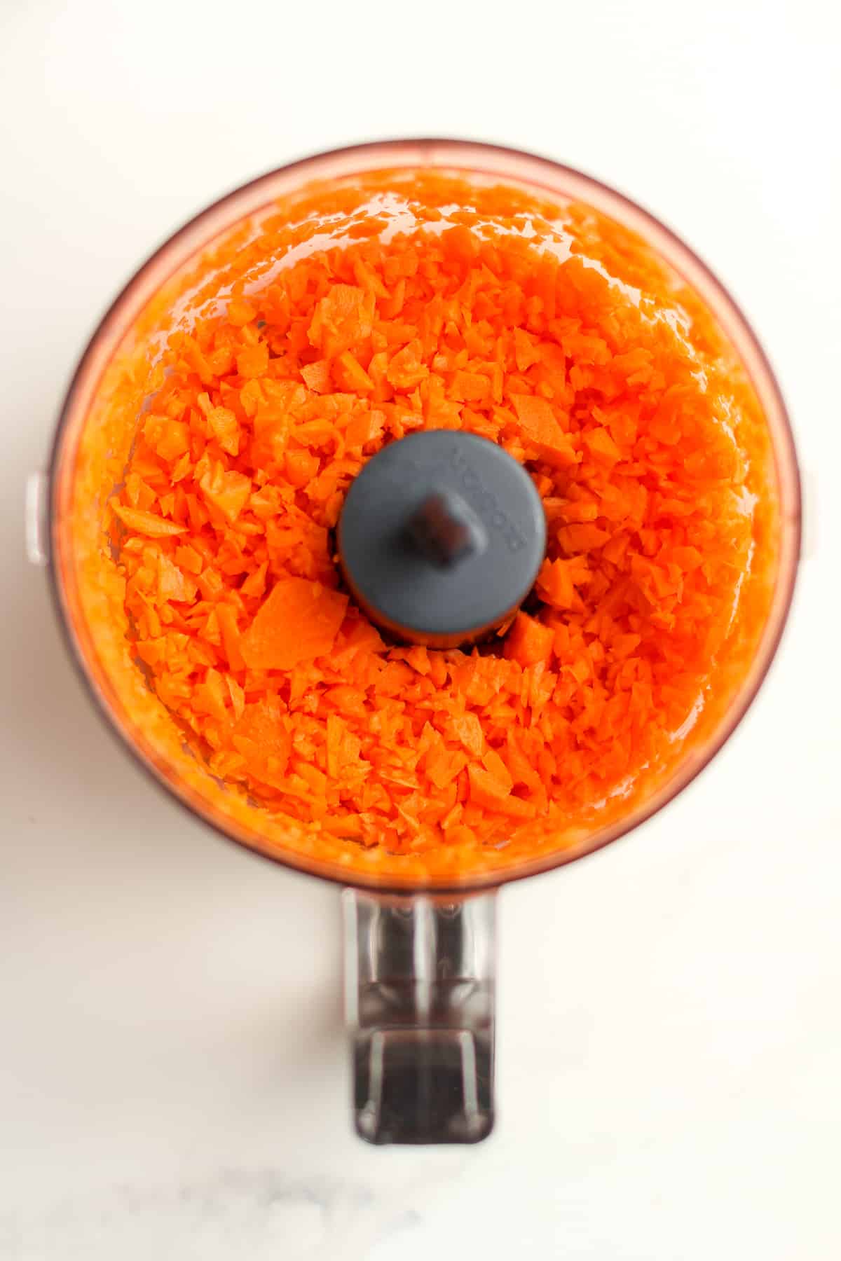 A mini food processor with shredded carrots.