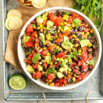 A bowl of cowboy caviar, with avocado and chips.