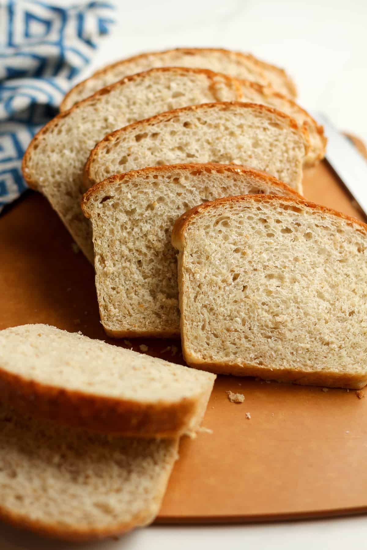 Side view of some sliced cracked wheat bread, on a cutting board.