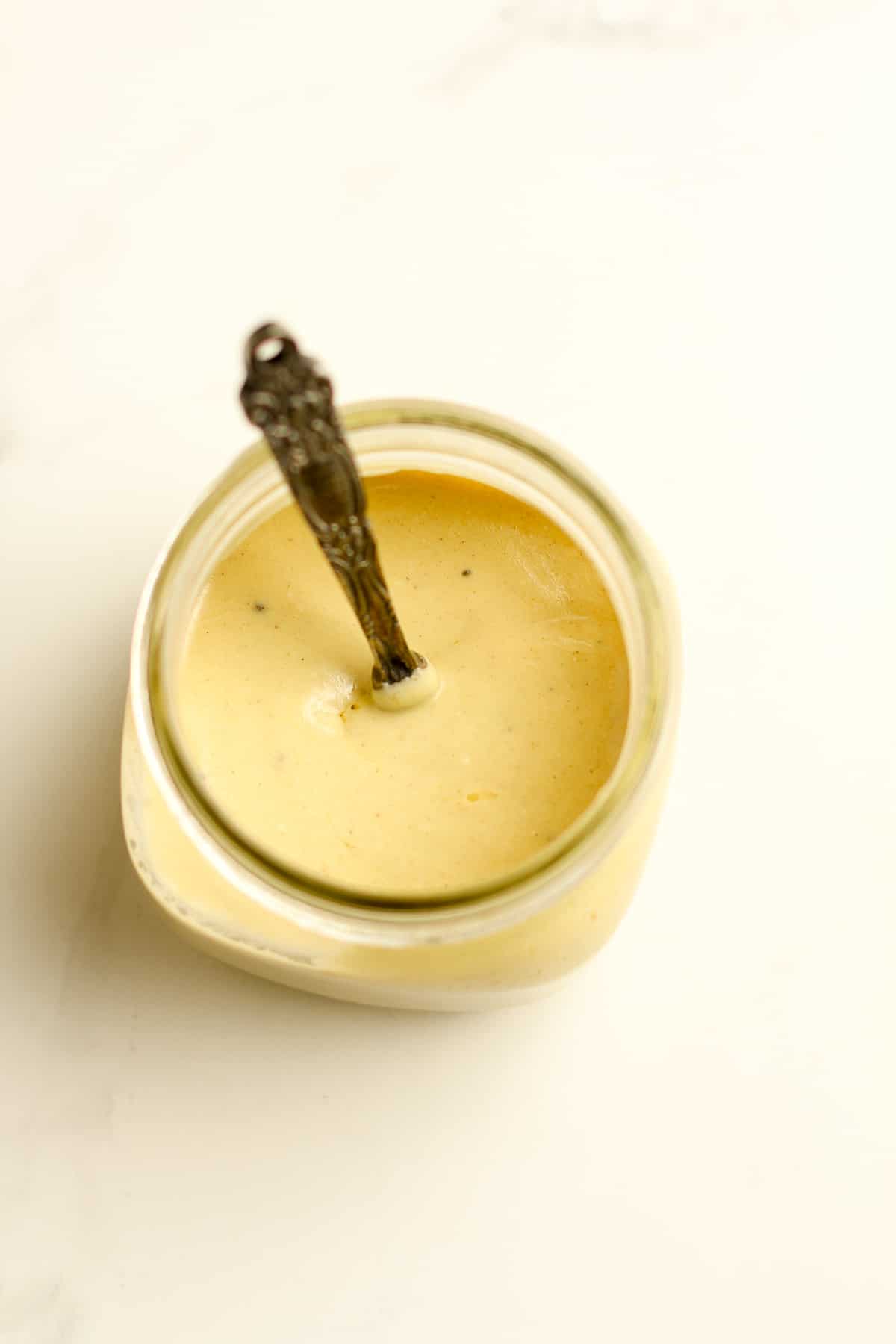 A jar of the light honey mustard with a tablespoon.