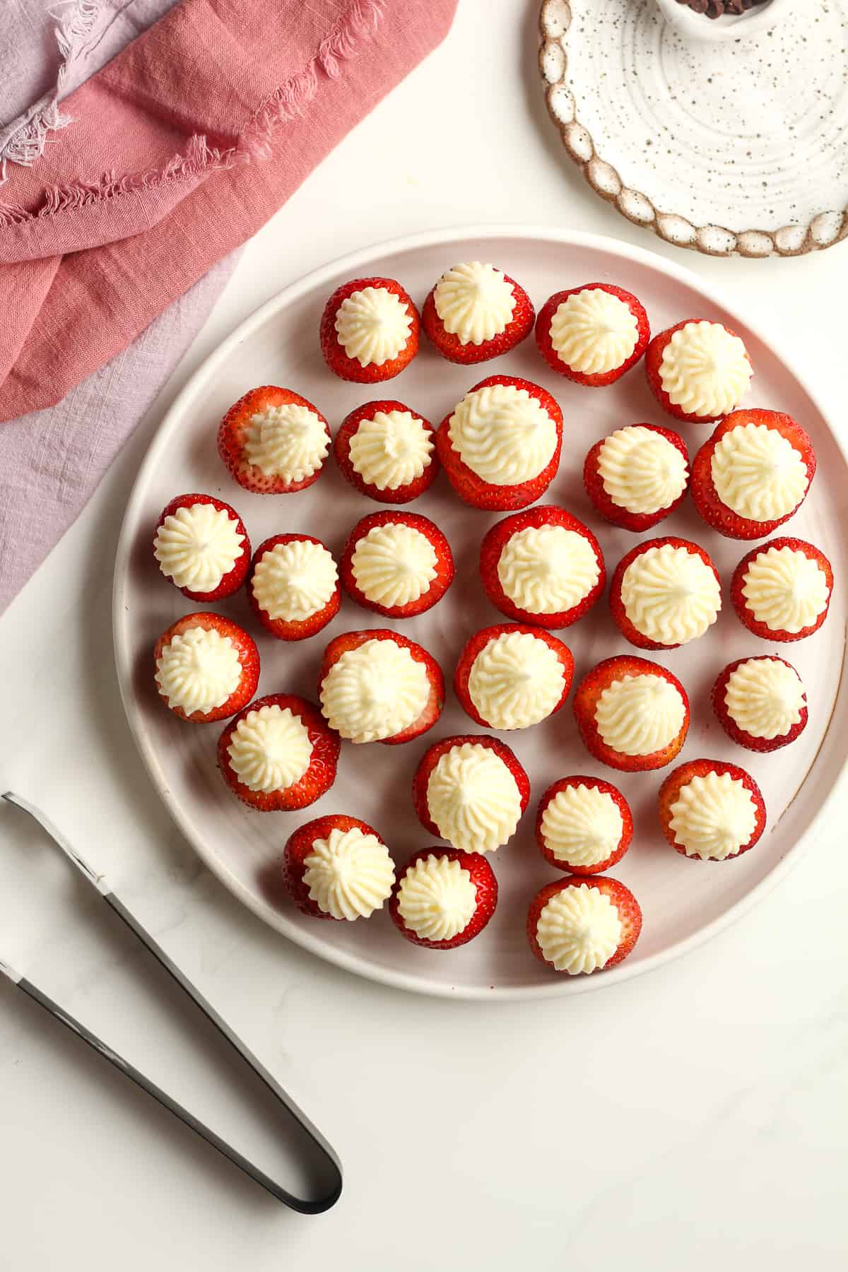 A white plate of the strawberry cheesecake bites.