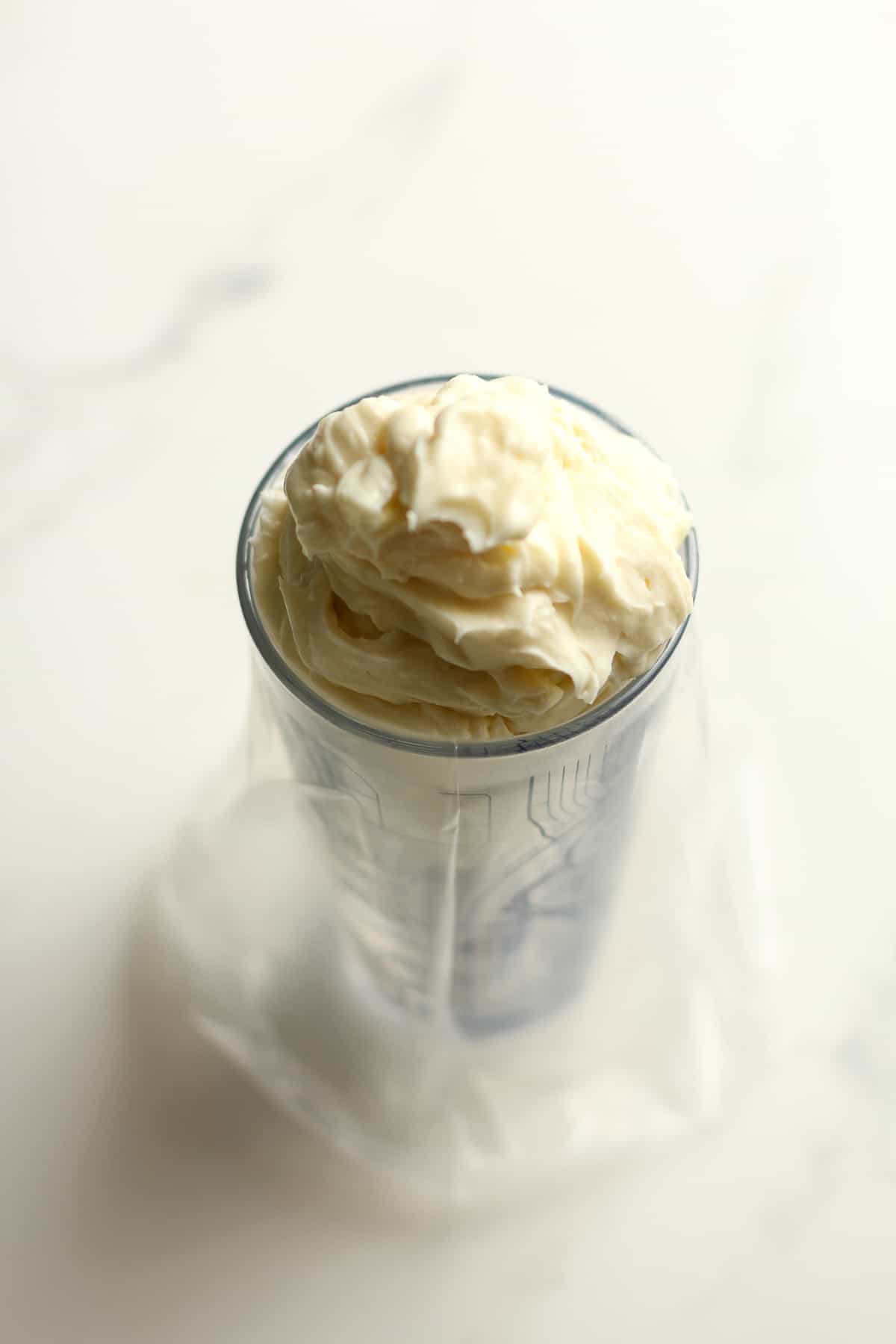A glass with a piping bag full of the cream cheese mixture.