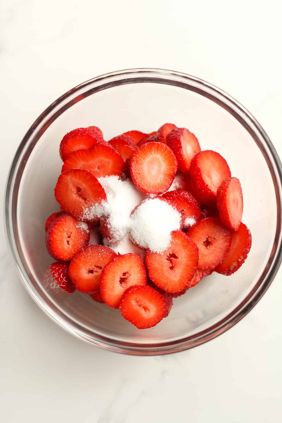 The sliced strawberries with some sugar on top.