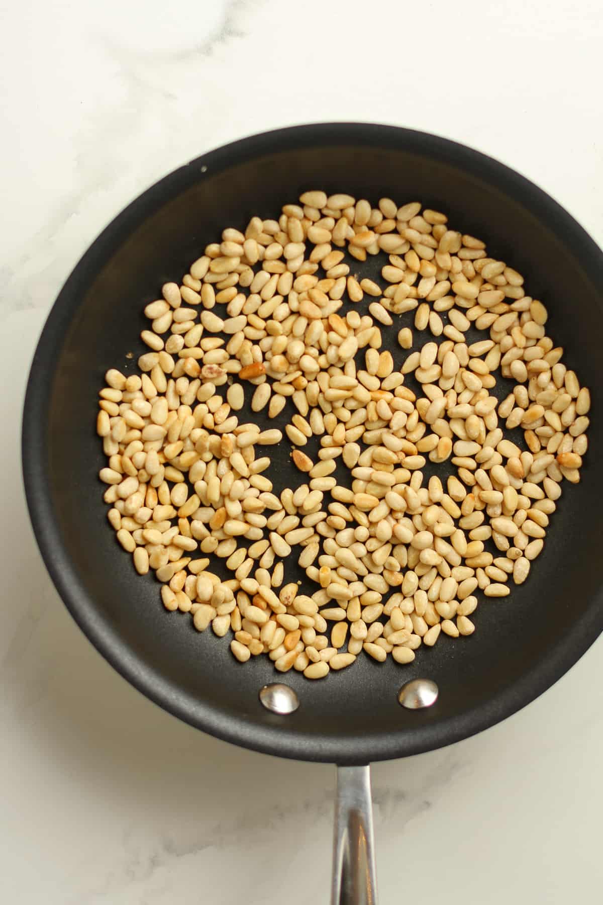 A pan of sautéed pine nuts.