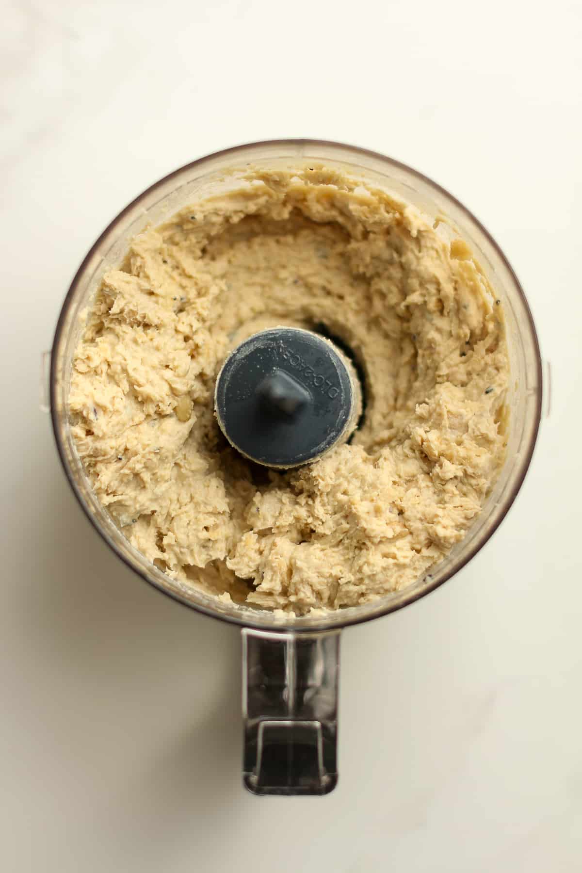 A small food processor of the blended hummus mixture before water added.