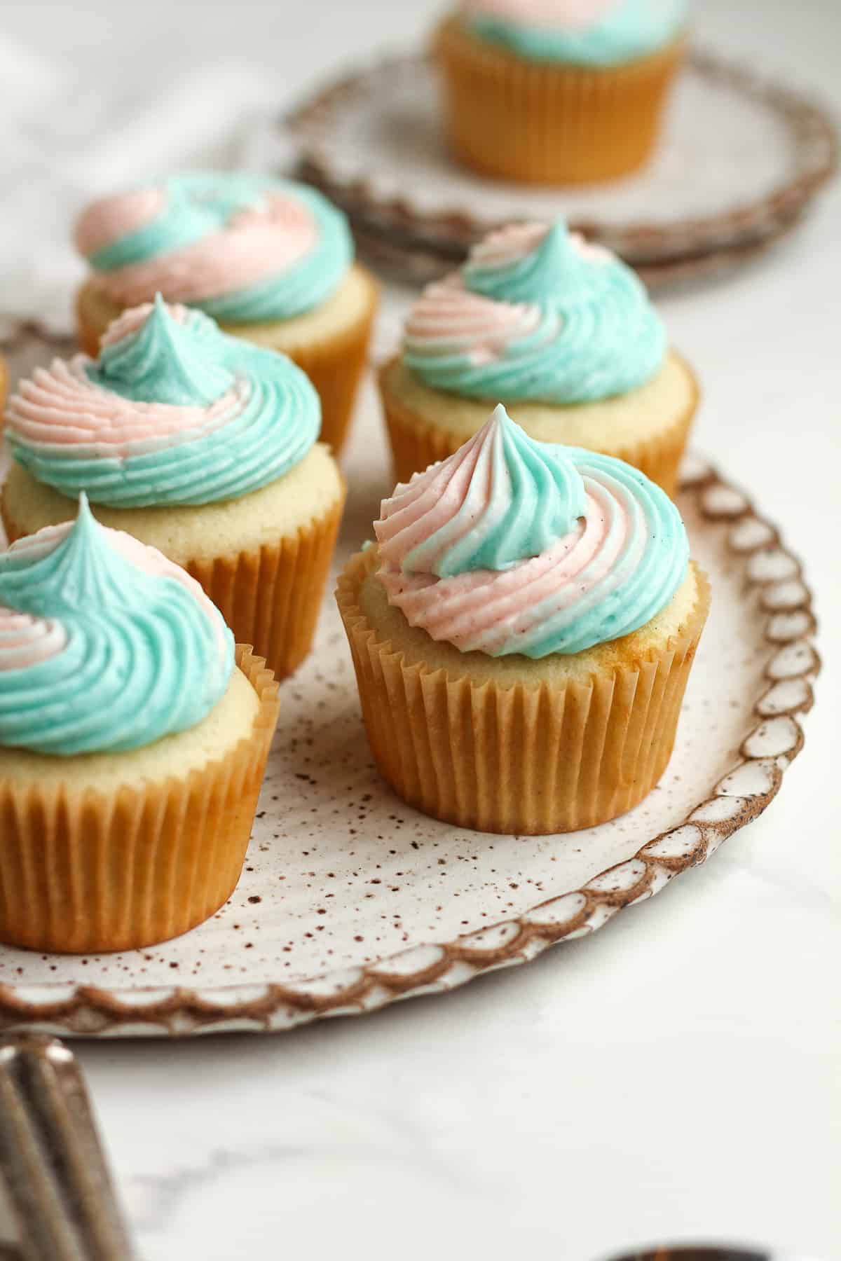Side view of some vanilla cupcakes with swirl frosting.