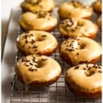Side view of a rack of banana donuts with brown sugar icing.
