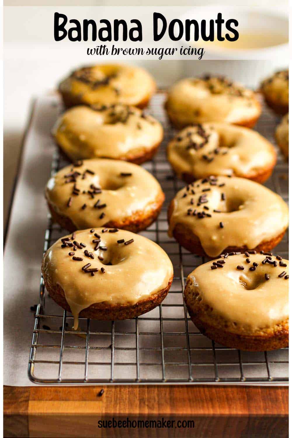 Side view of a rack of banana donuts with brown sugar icing.