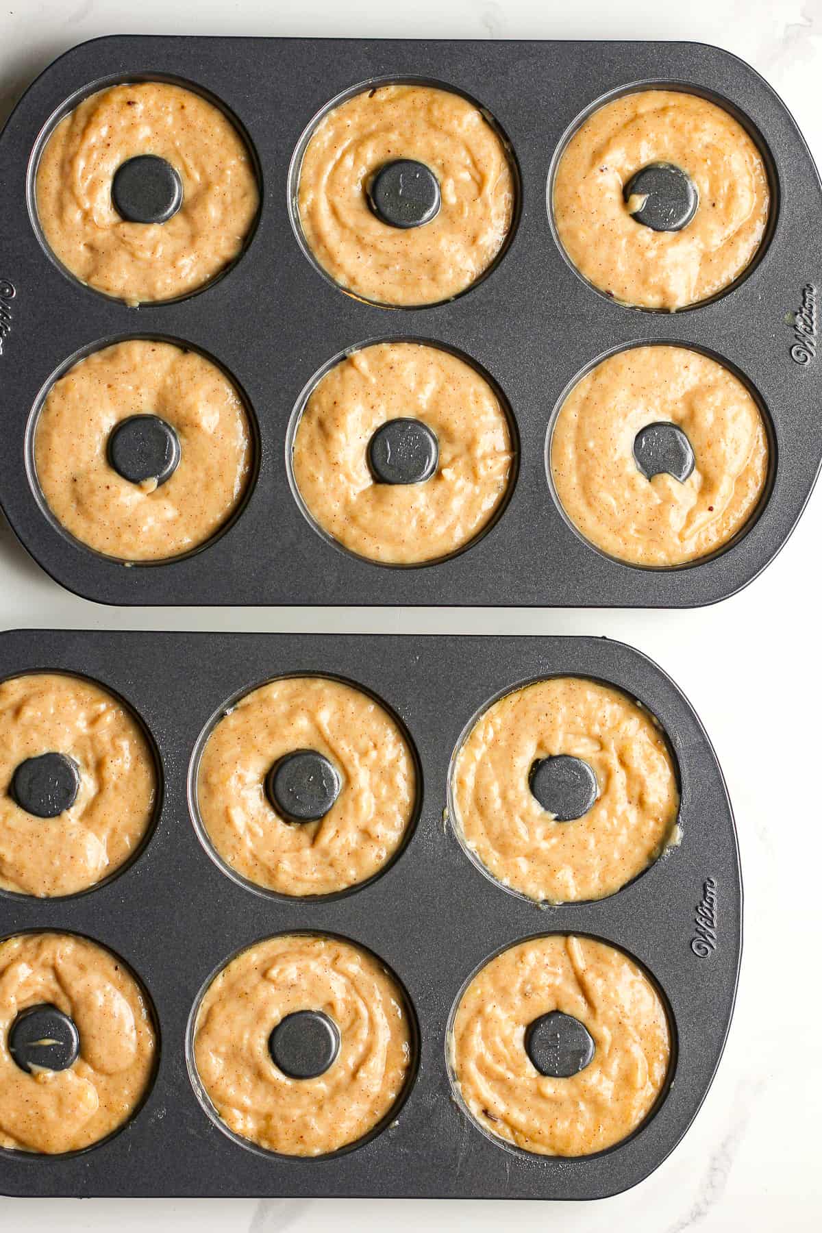 Two donut pans willed with banana batter.
