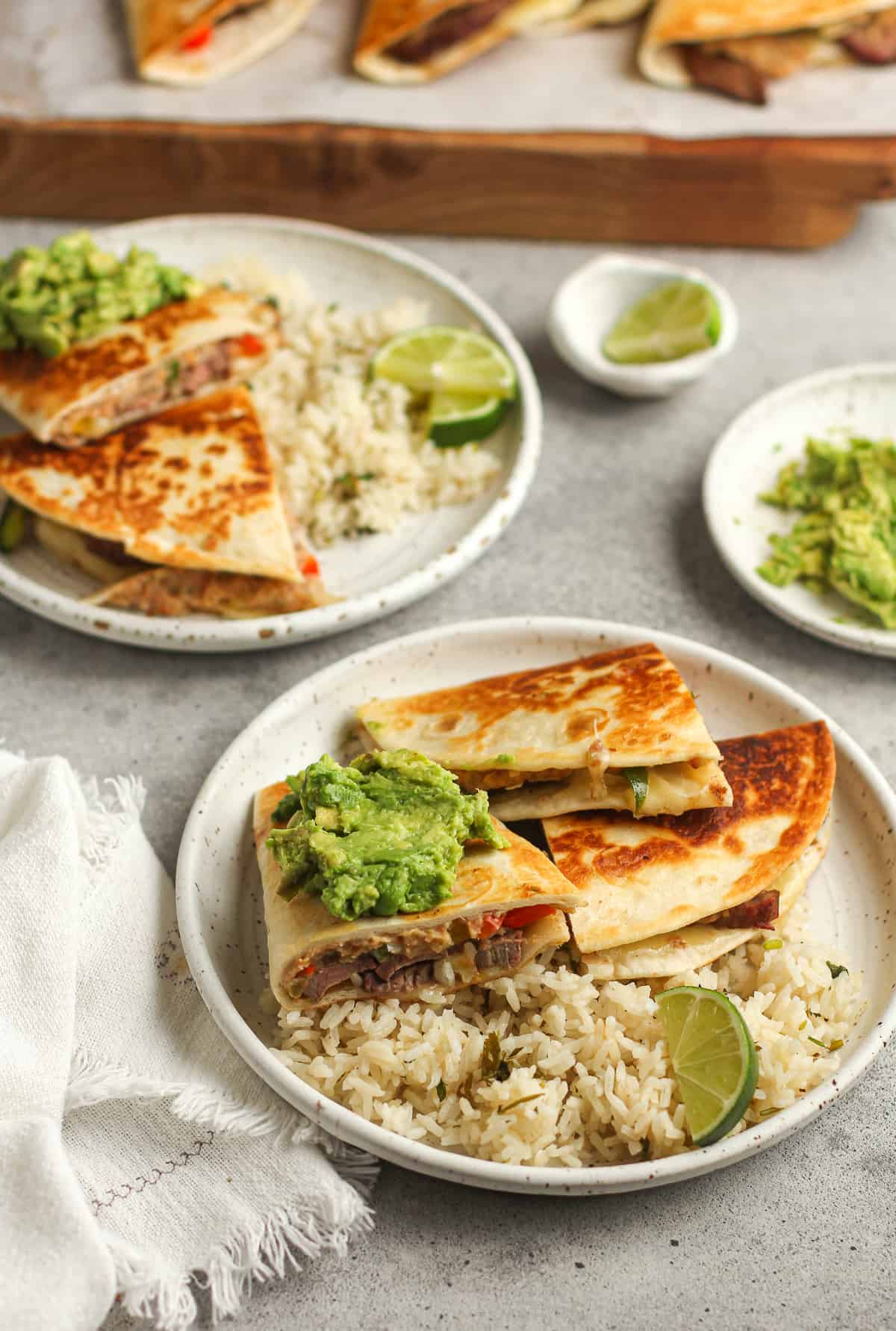 Side shot of two plates of quesadillas and rice.