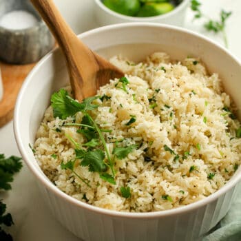 A bowl of cilantro lime rice with a wooden spoon inside.