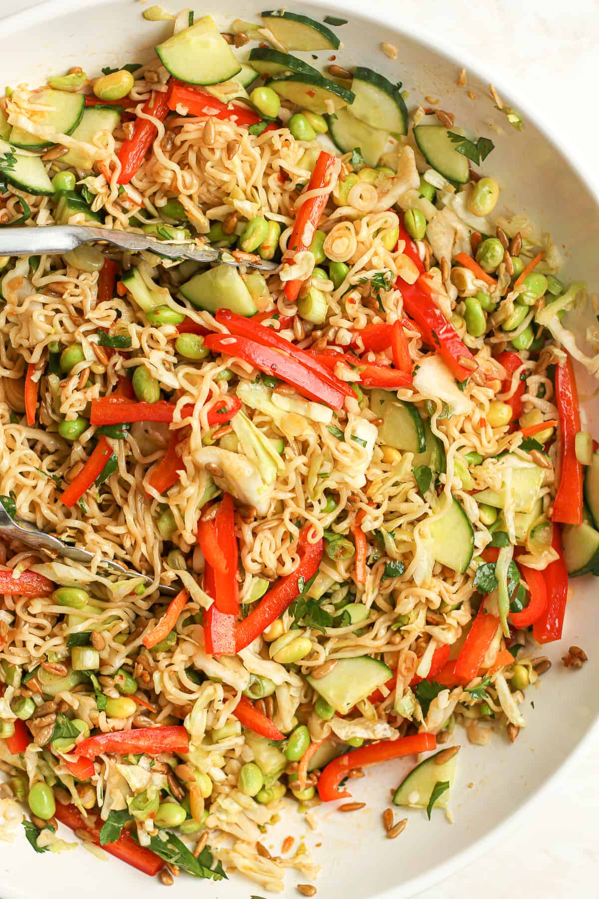 A bowl of the ramen salad with cucumbers and peppers.