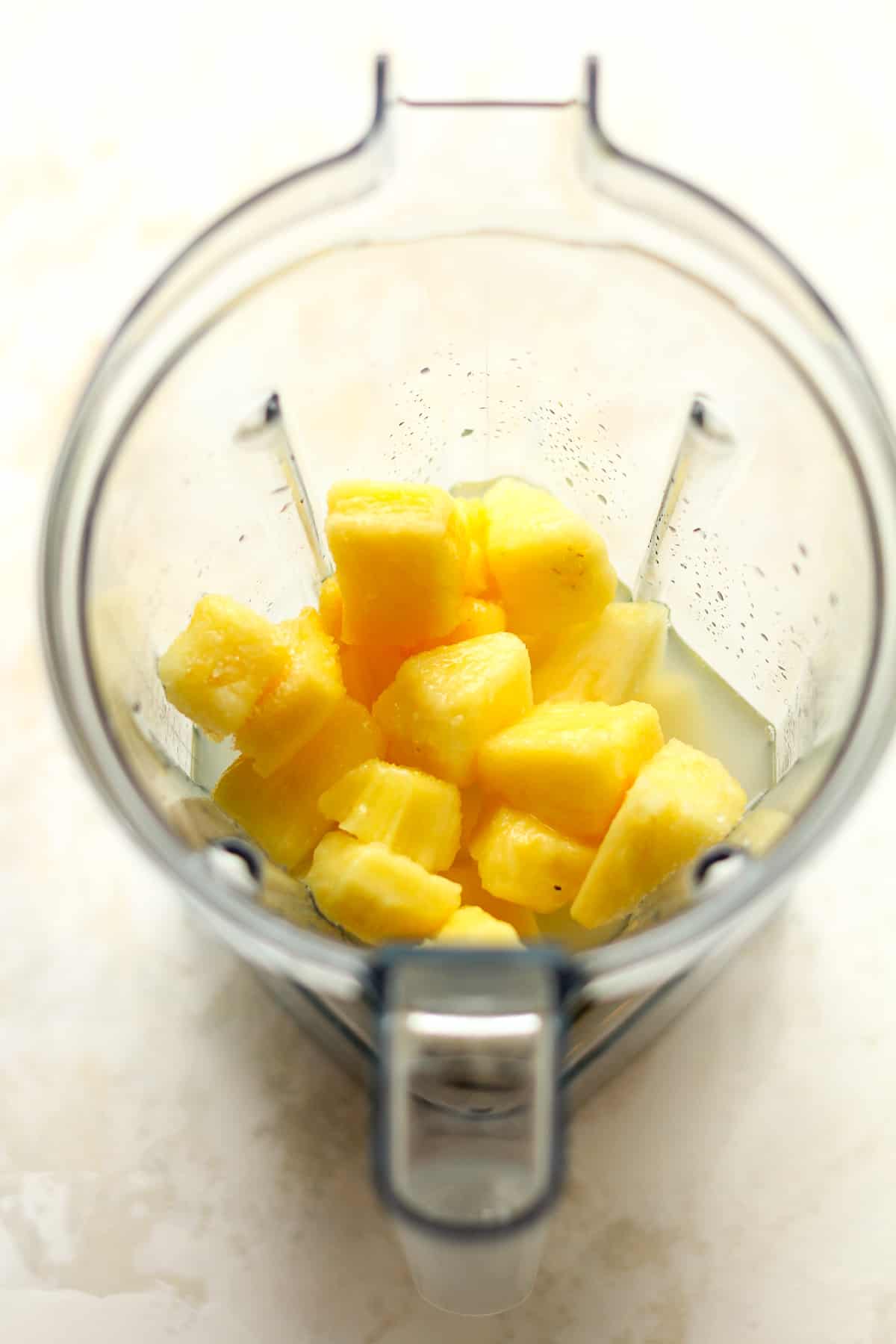 A blender of the marg ingredients including frozen pineapple.