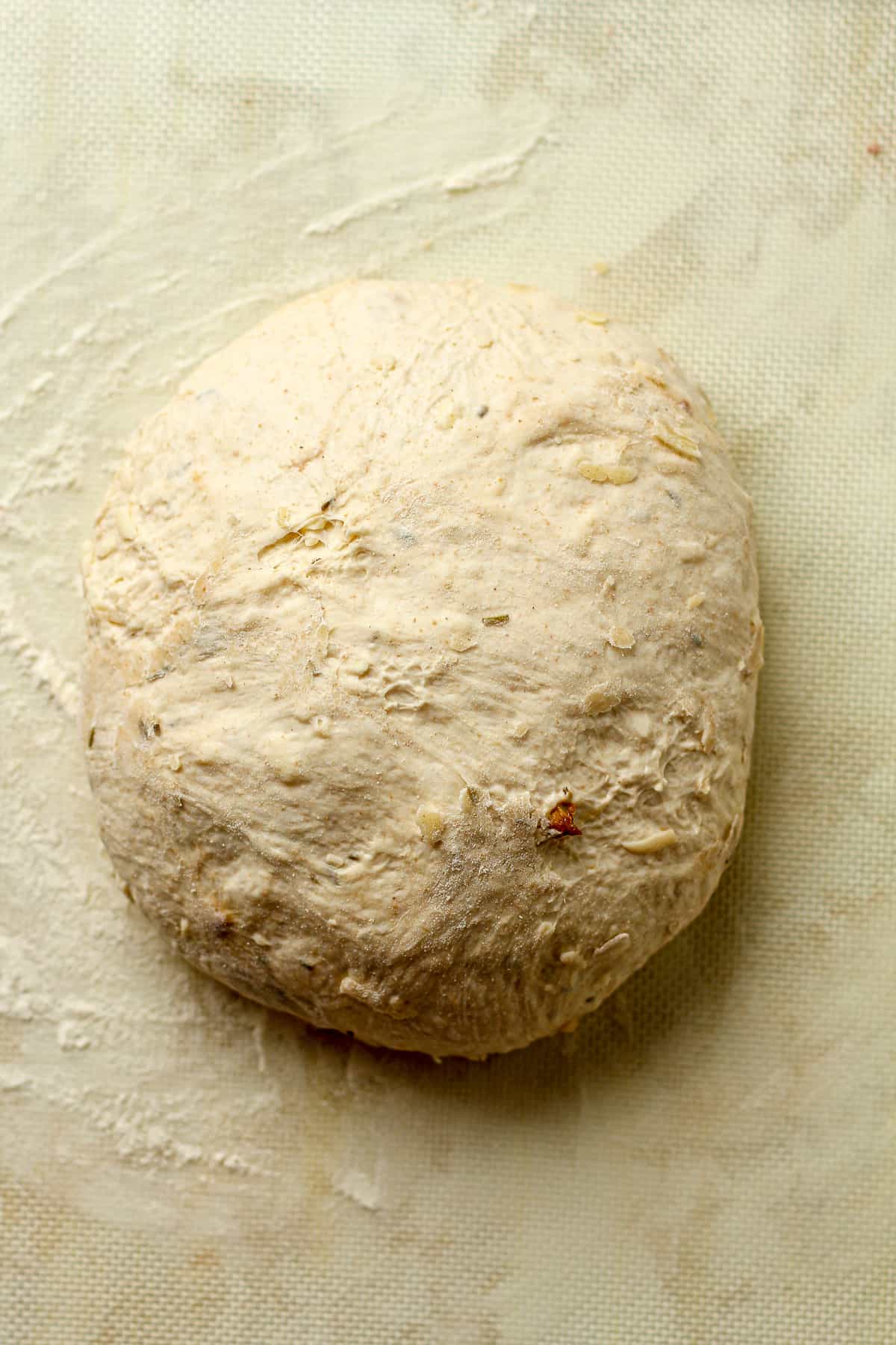 A round of sourdough on a baking mat.
