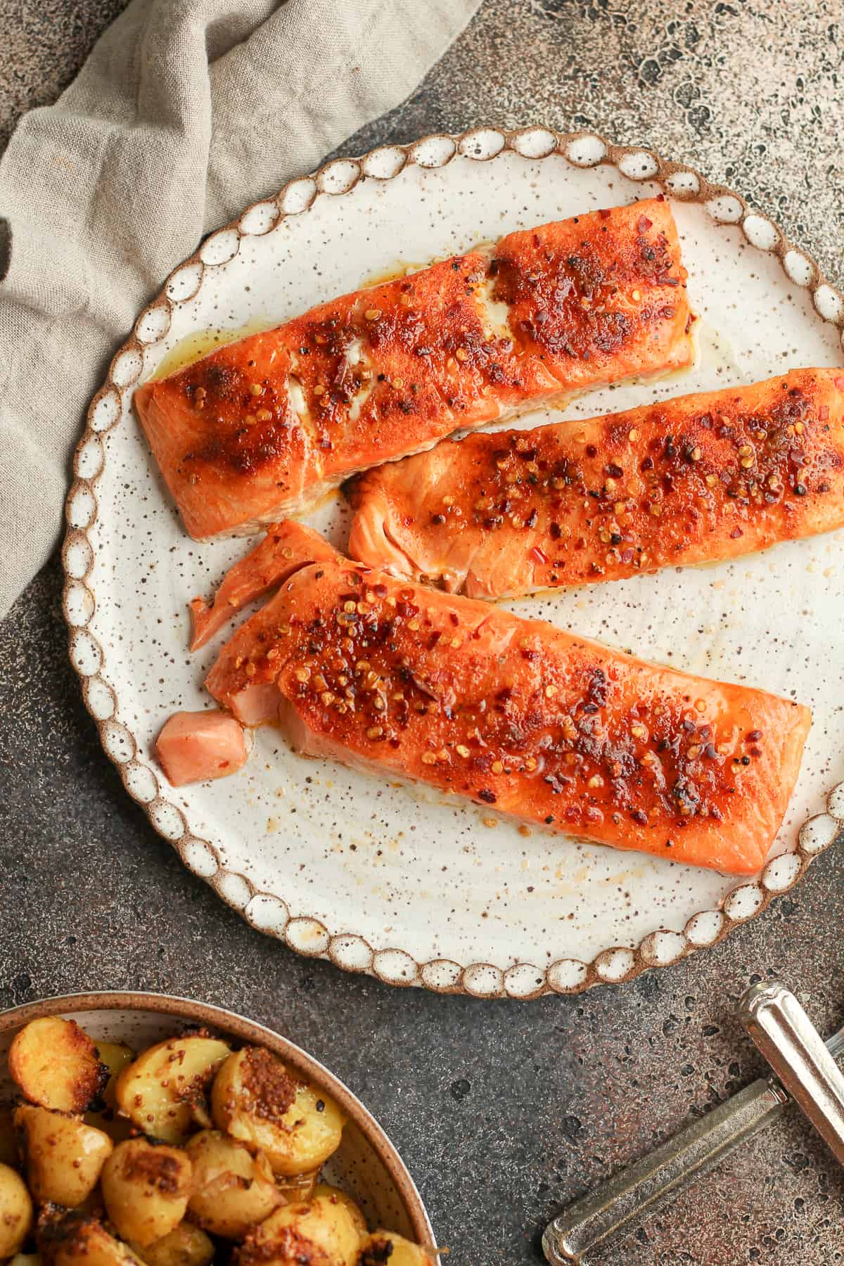 A plate of the grilled cedar plank salmon on a dark background.