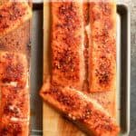 A pan with two cedar planks topped with grilled salmon.