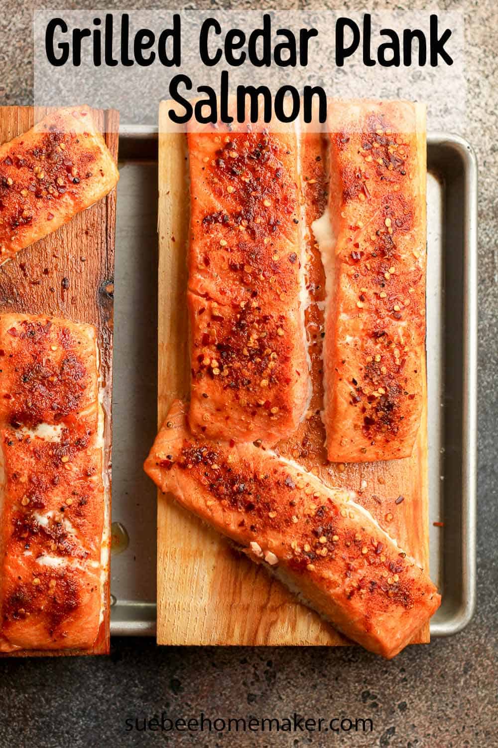 A pan with two cedar planks topped with grilled salmon.