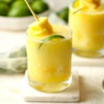 Side view of two frozen pineapple margaritas with pineapple garnish.