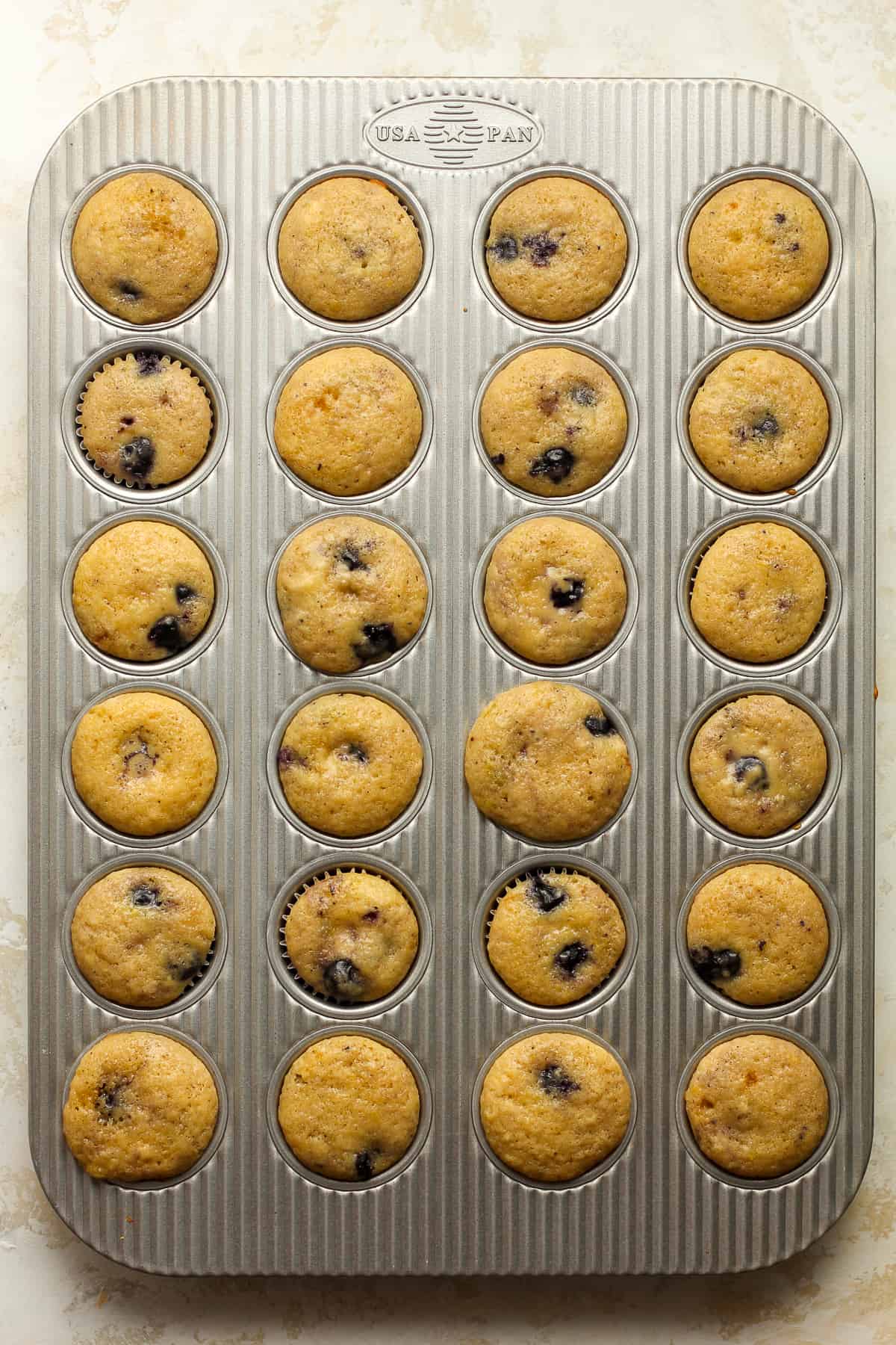 A muffin tin with baked mini muffins.