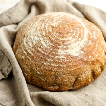 Side view of a round loaf of sourdough bread with multigrain.