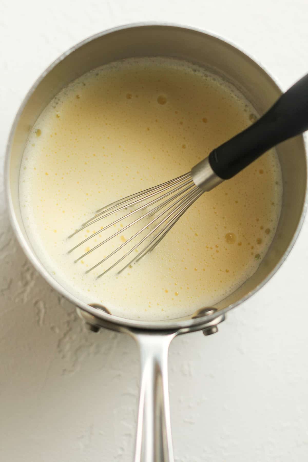 a pan of the tempered egg mixture with a whisk.