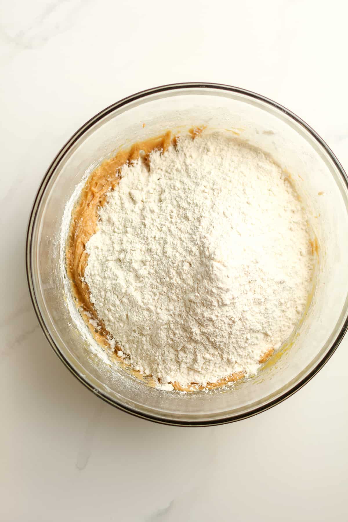 A bowl of the dough with the flour on top.