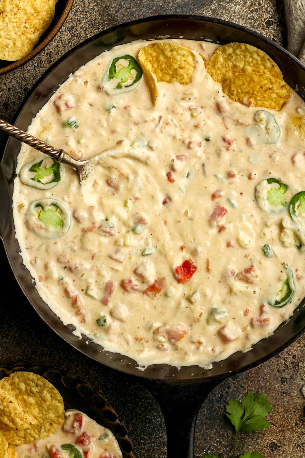 Overhead shot of a cast iron skillet of white queso dip.