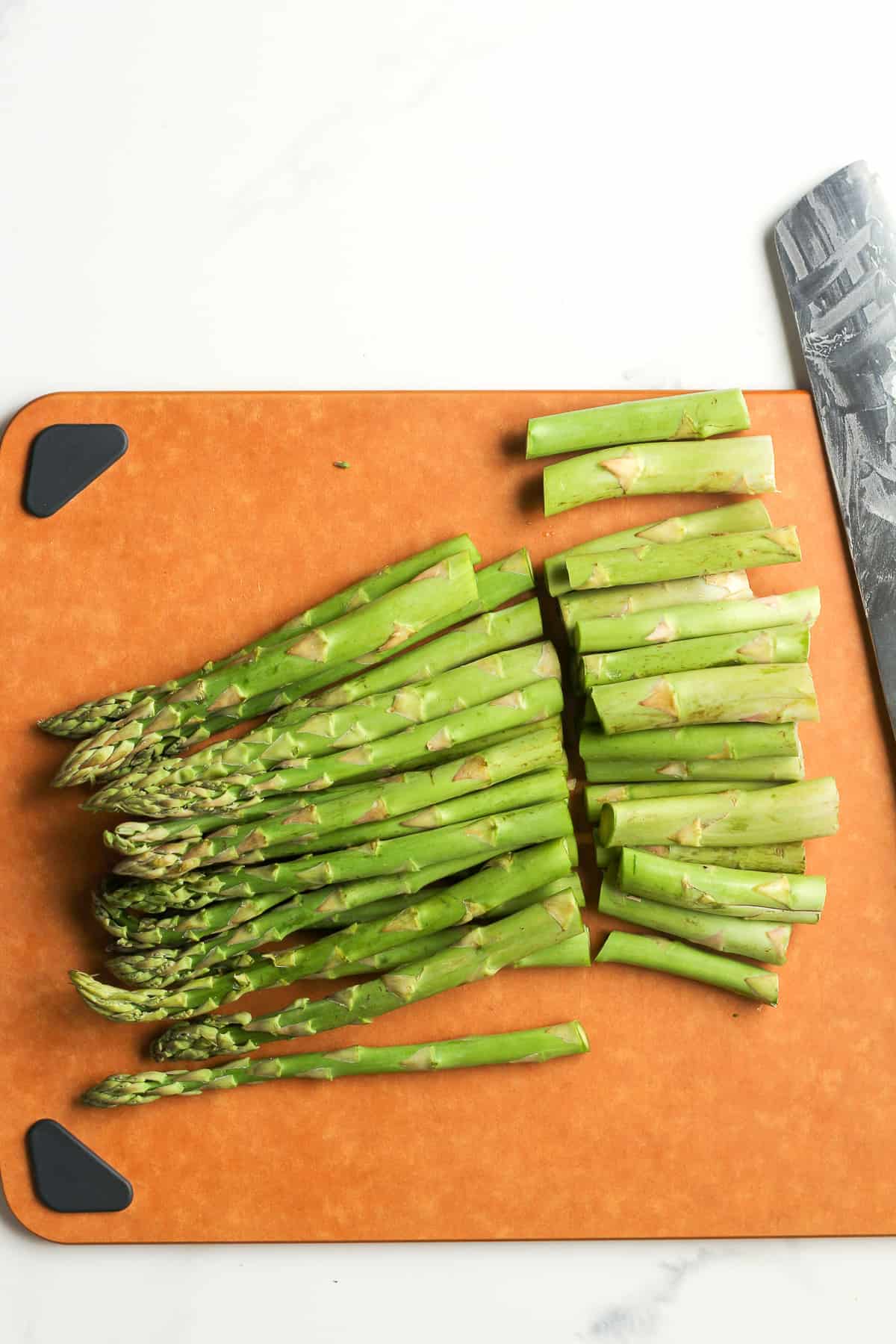 A cutting board of the asparagus with the ends trimmed off.