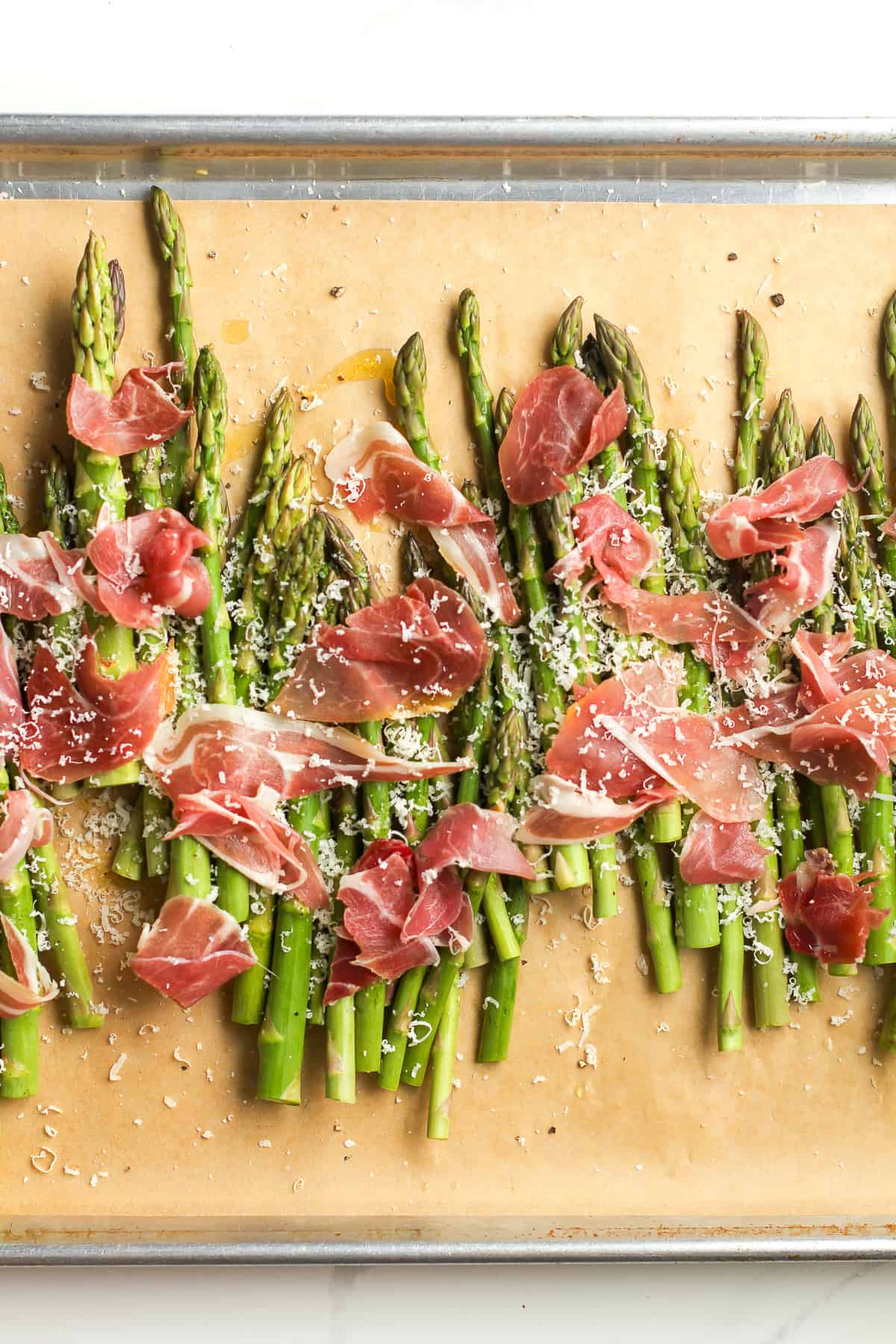 The asparagus plus toppings on a sheet pan.
