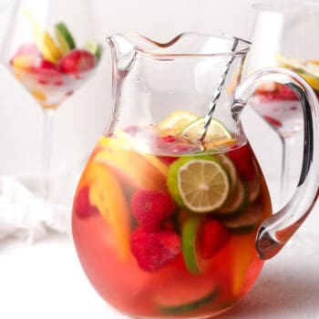 A pitcher of rose sangria with fruit.