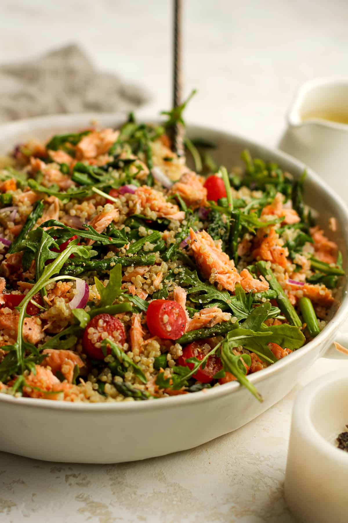 Side view of a salmon quinoa salad with arugula.