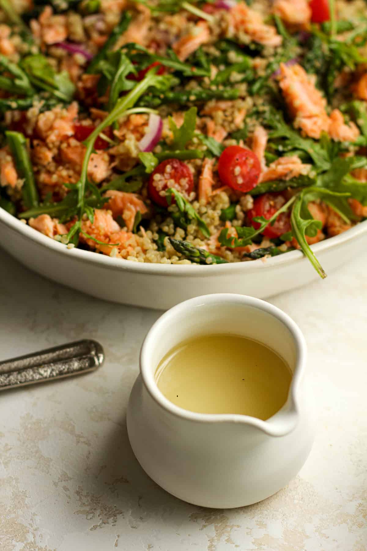 The lemon dressing in front of the salmon quinoa salad.