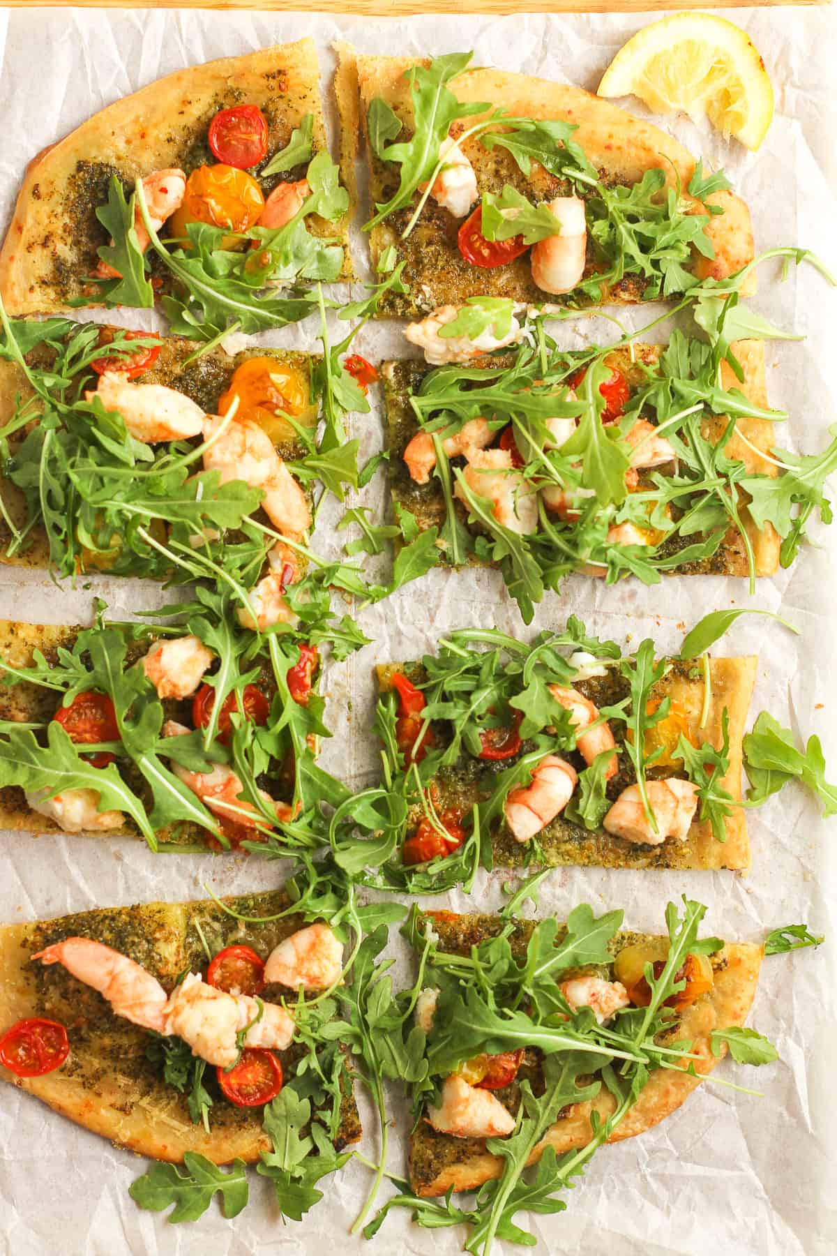 A shrimp pesto flatbread pizza sliced in 8 squares.