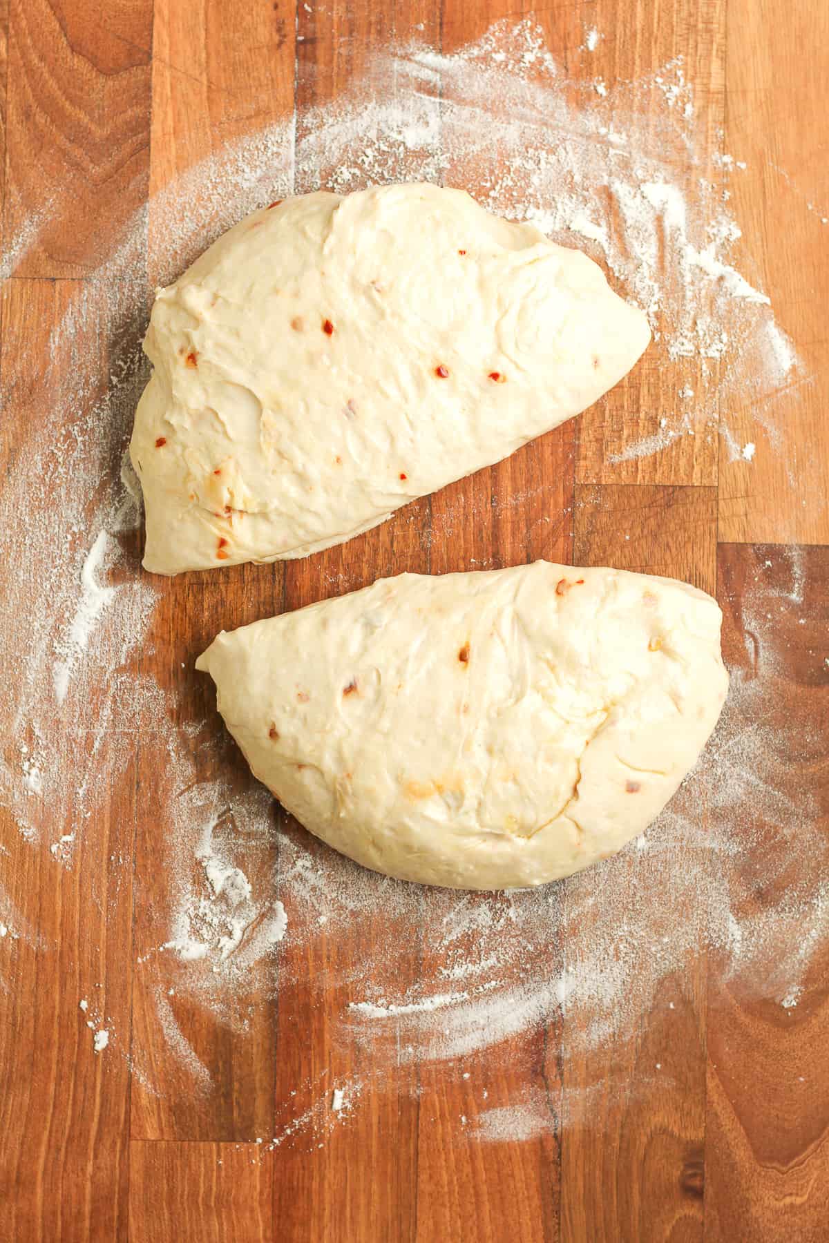 A round of dough cut in half for pizza making.