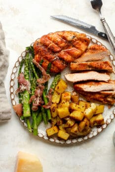 Overhead view of a plate of dinner, including smoked chicken, asparagus, and mustard potatoes.