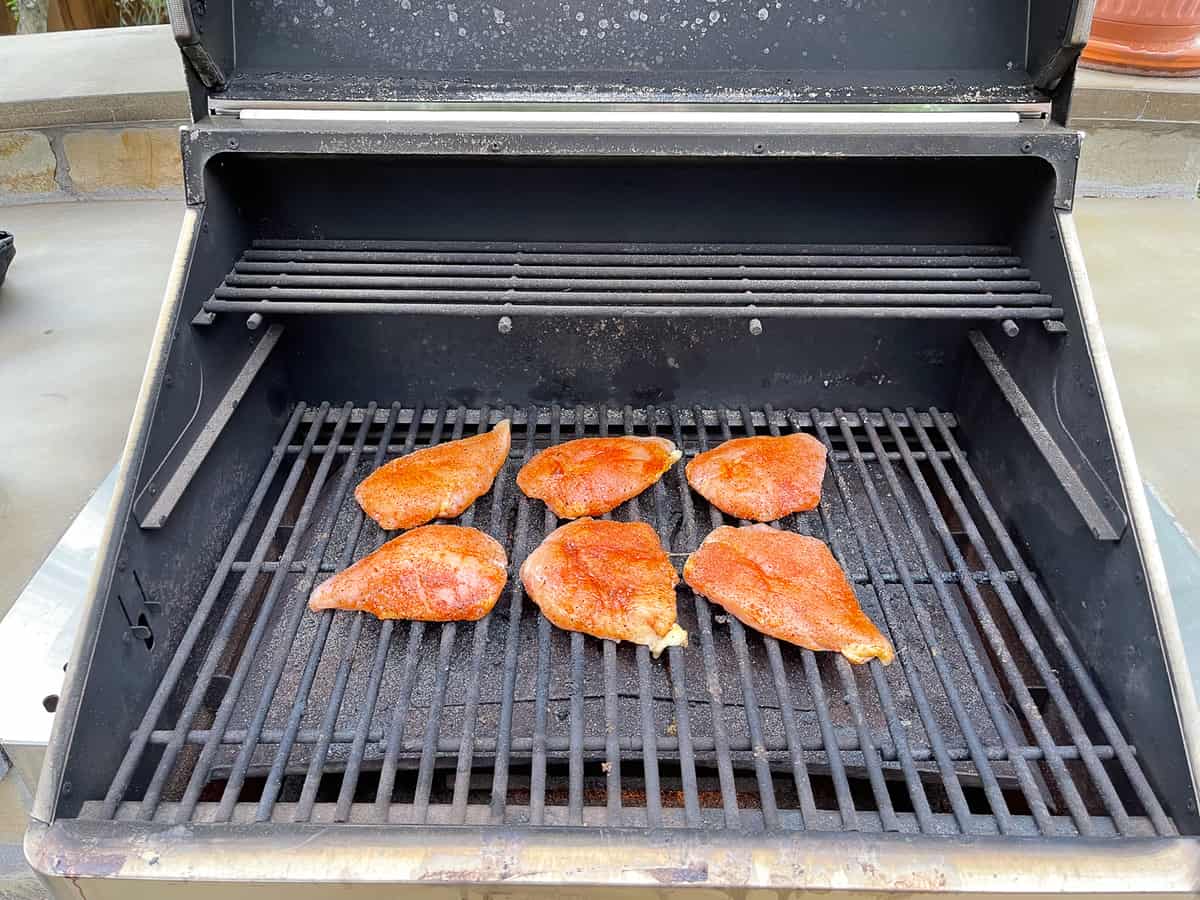 A smoker with the chicken breasts on the grates.