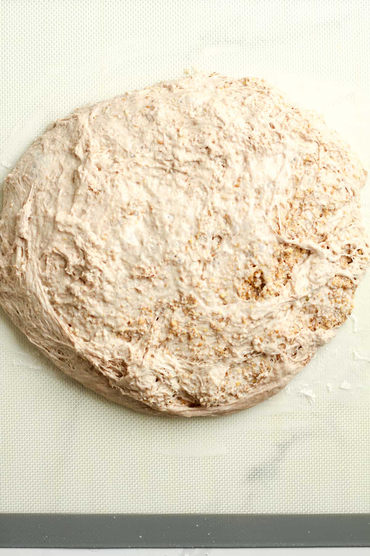 The multigrain dough on a baking mat after dumping it there.