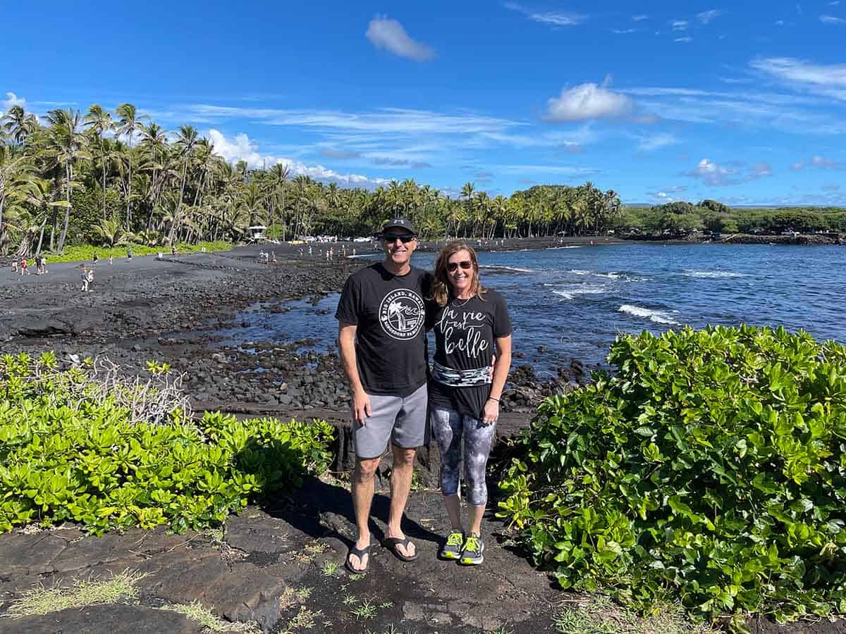 Mike and Sue standing in front of the black sand beach.