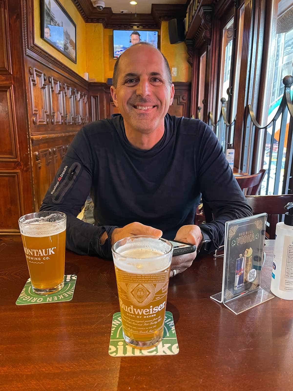 Mike drinking beer at bar.