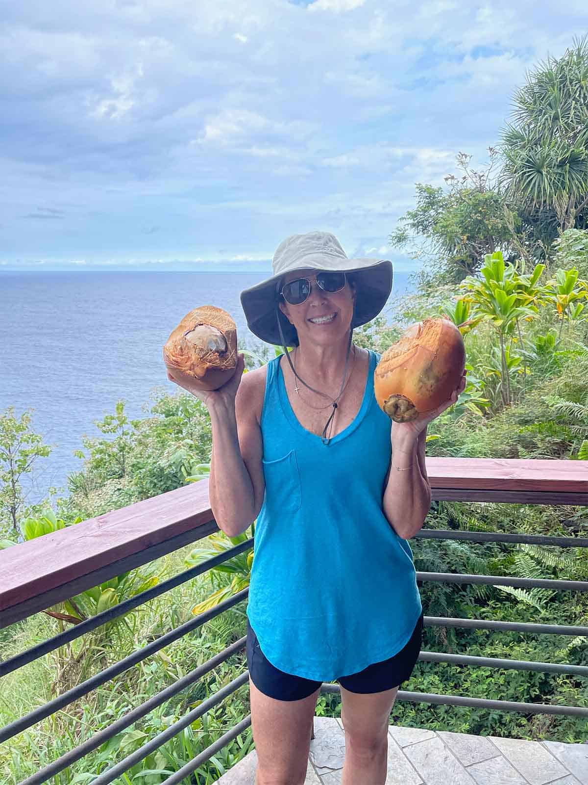 Me holding two coconuts on our deck.