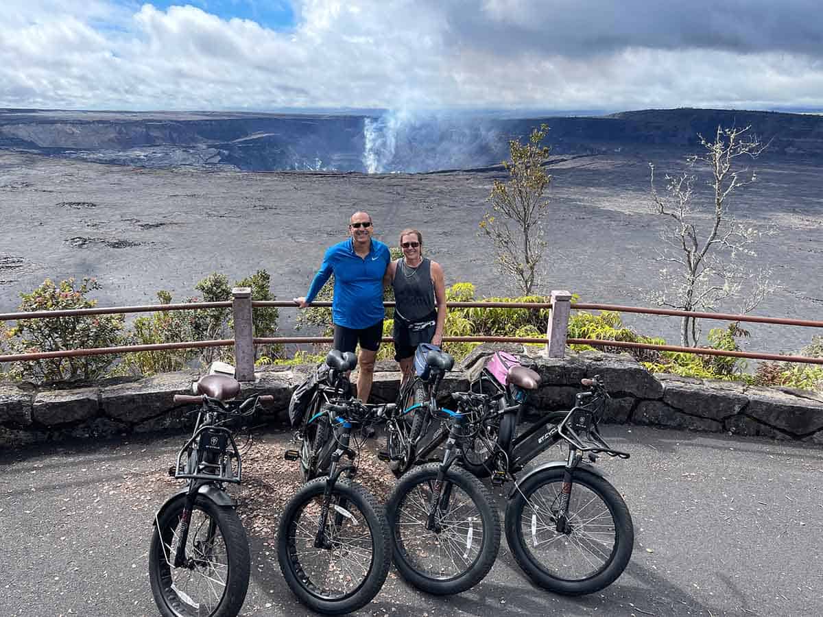 Sue and Mike with e-bikes on the edge of the volcano.