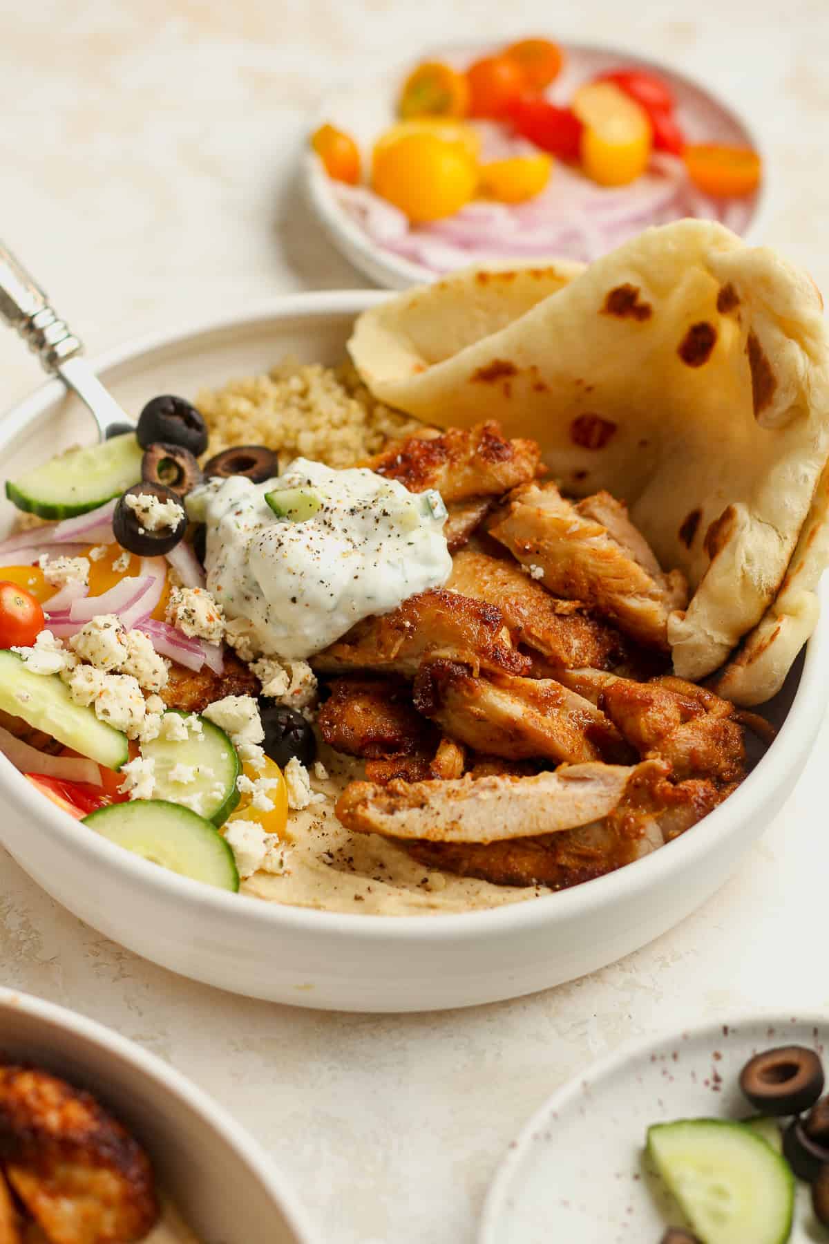A bowl of the chicken hummus bowls with toppings.