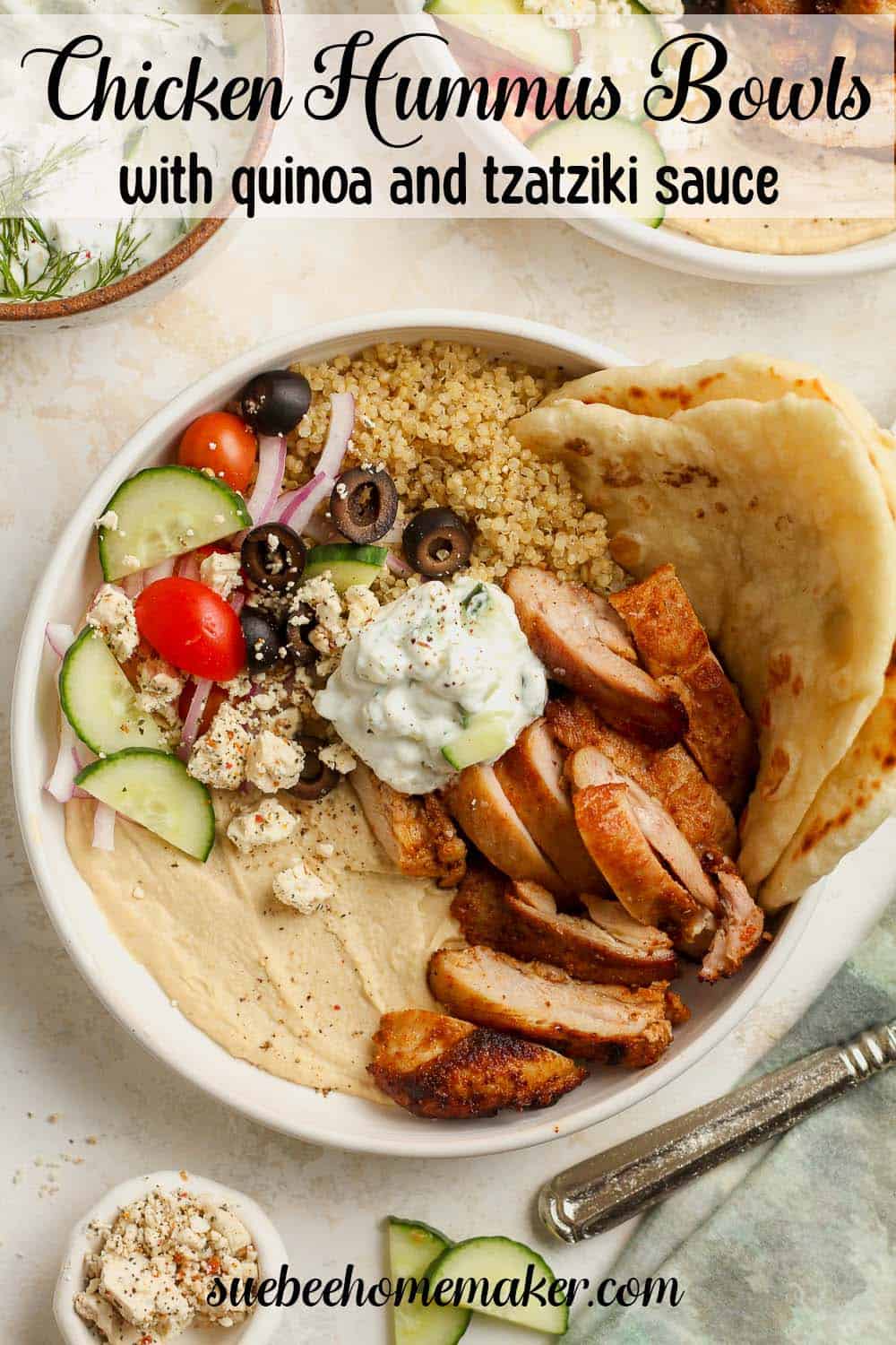 A chicken and hummus bowl with quinoa, tzatziki sauce, and veggies.