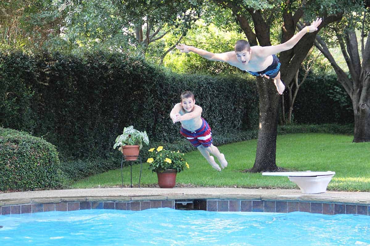 Josh and Zach simultaneously diving into our swimming pool.