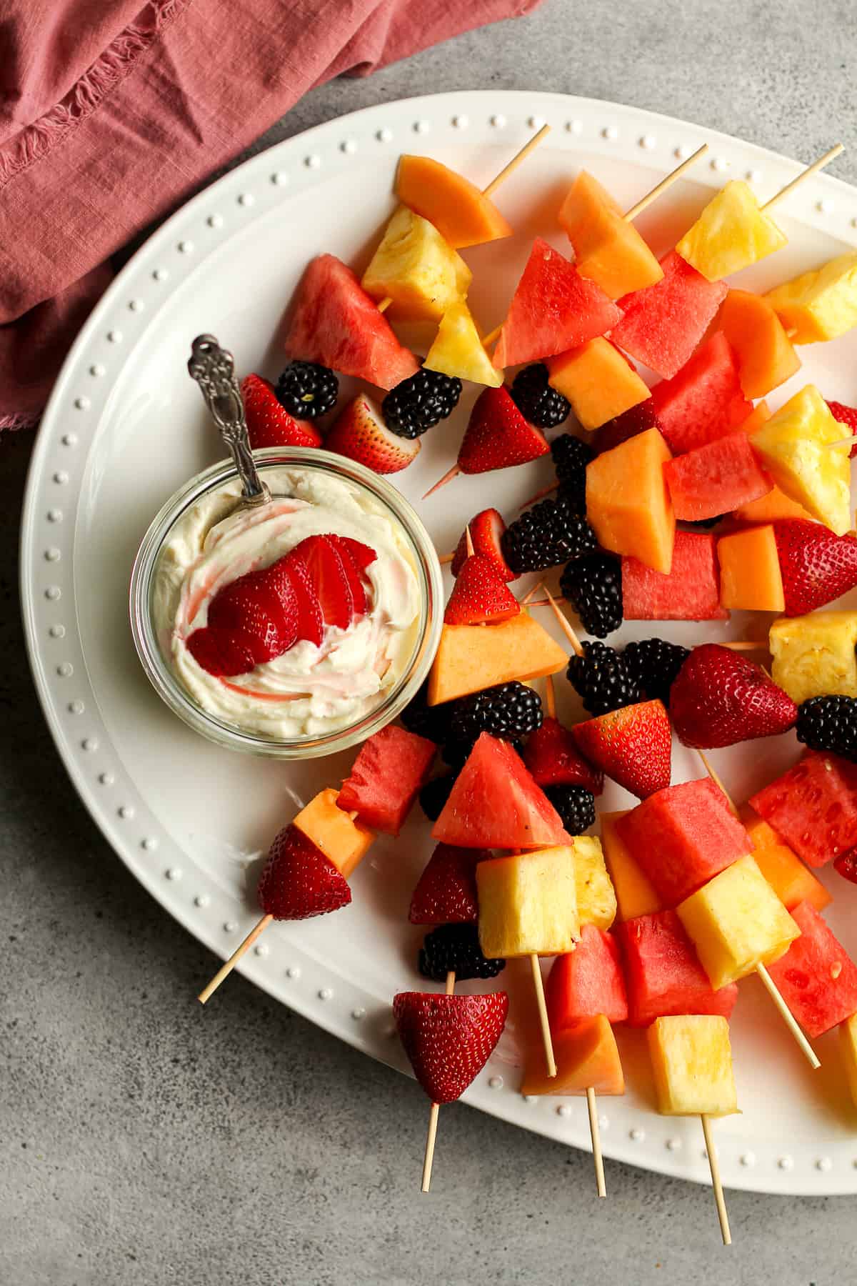 Overhead shot of a white platter of fruit and fruit dip.
