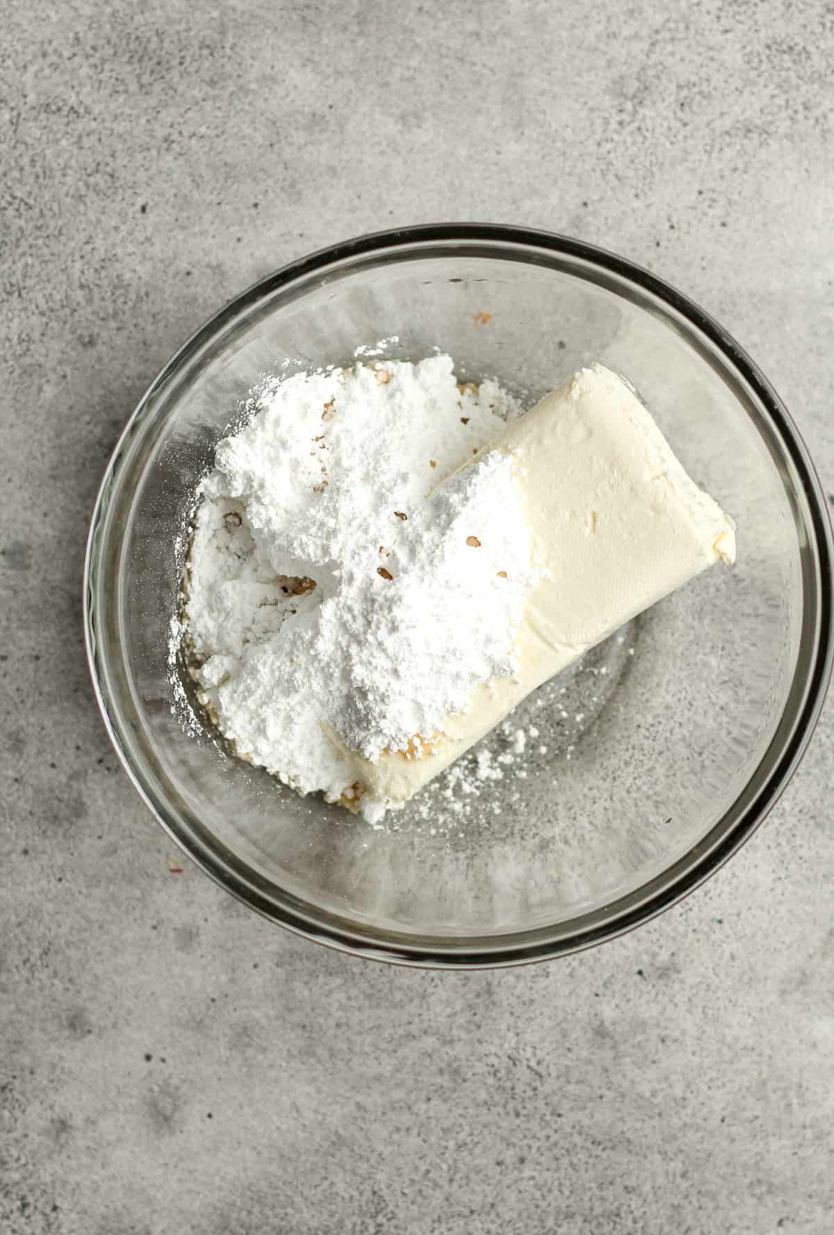 A bowl of the cream cheese, powdered sugar, vanilla - before mixing.